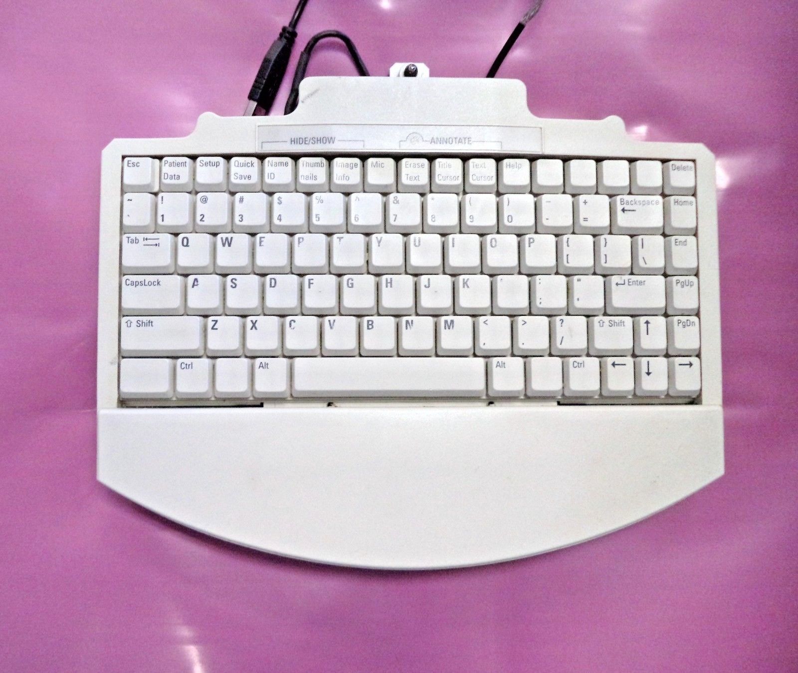 a white computer keyboard sitting on top of a purple table