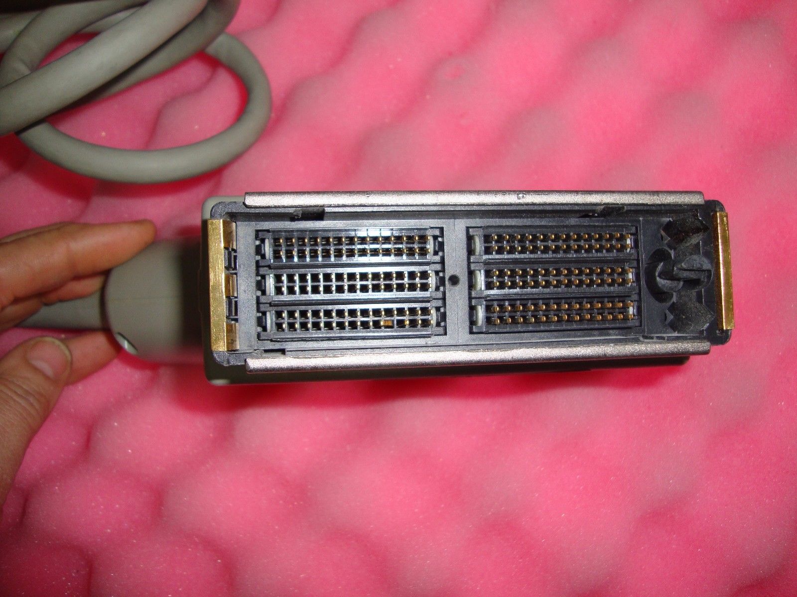 a close up of a small electronic device on a pink surface