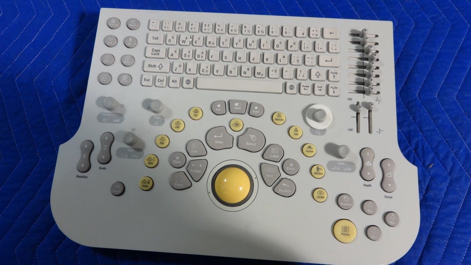 a computer keyboard sitting on top of a blue blanket